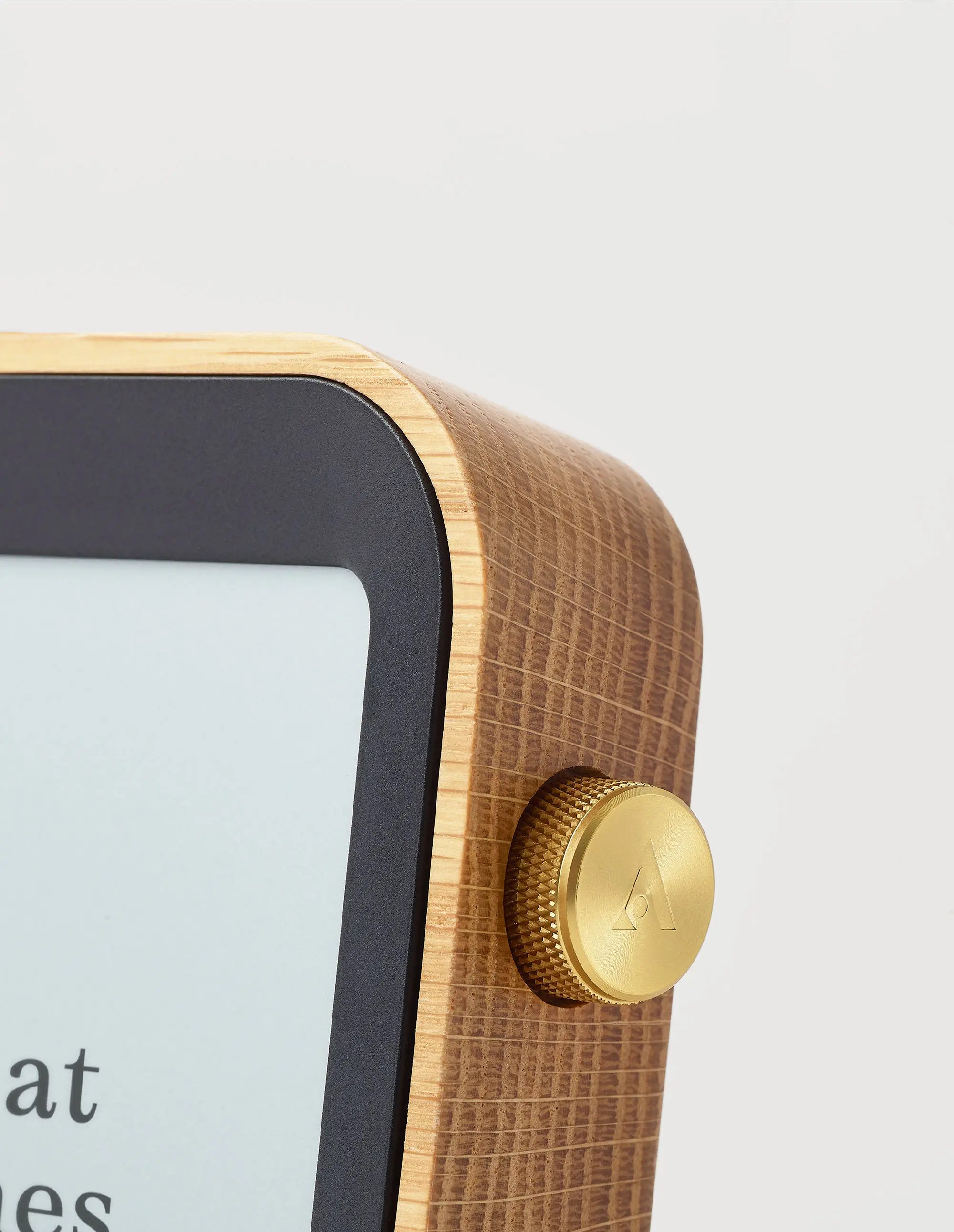 An up close detail shot of the Author Clock's brass crown and oak body