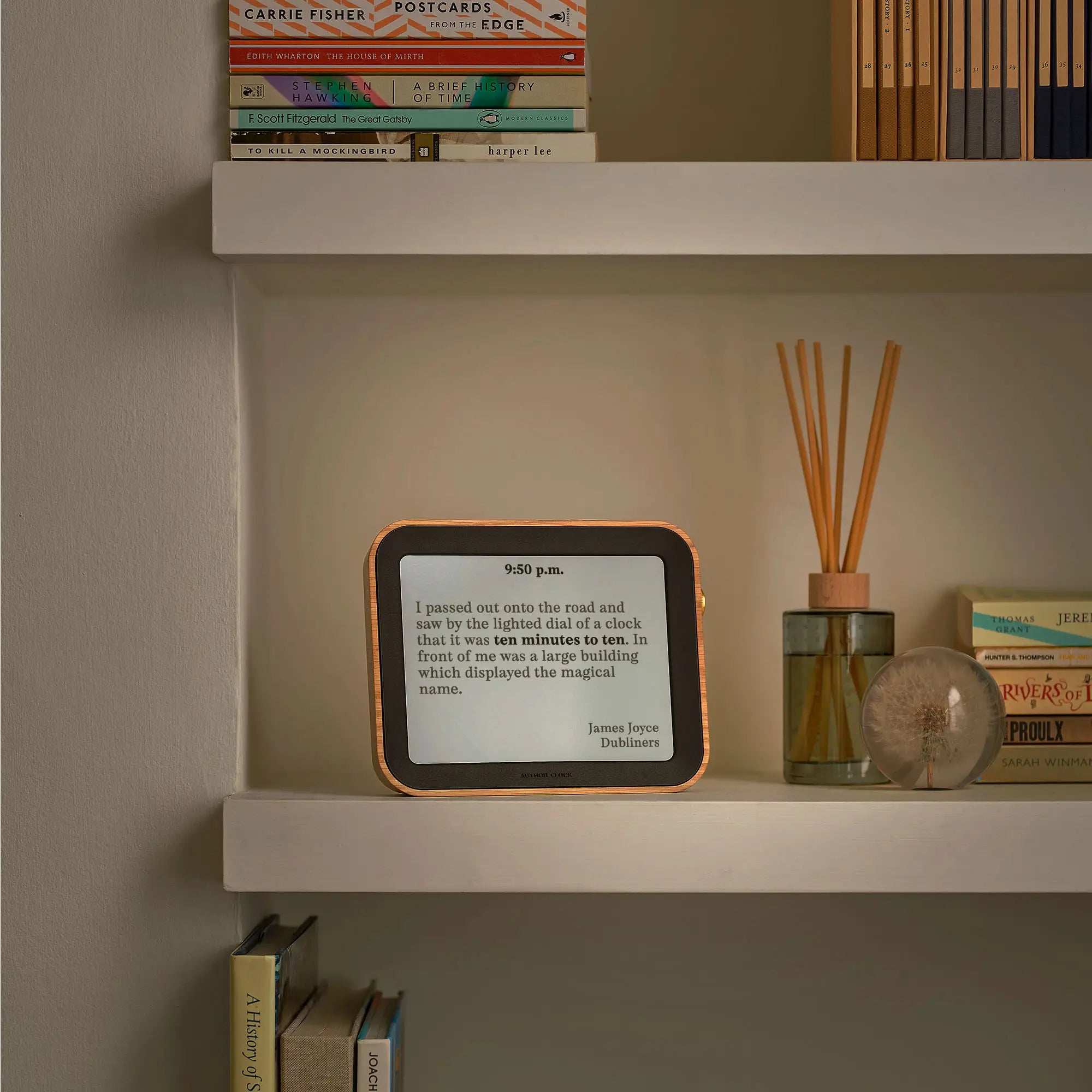 Author Clock Vol 2 Large on a bookshelf under warm evening light, displaying a quote from James Joyce’s Dubliners.