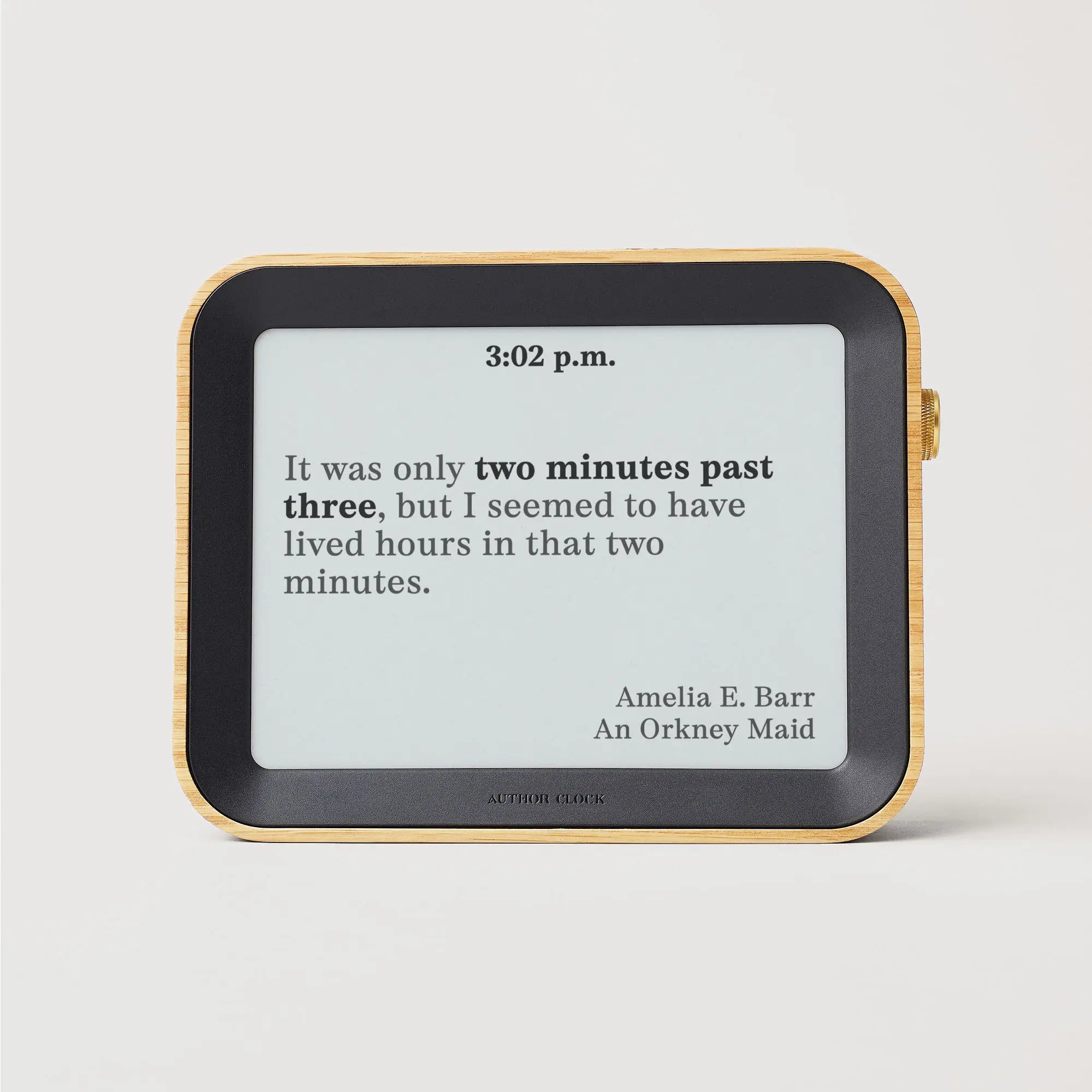 Author Clock Vol 2 Large showing a 3:02 p.m. display with a quote from Amelia E. Barr’s An Orkney Maid, against a white background.
